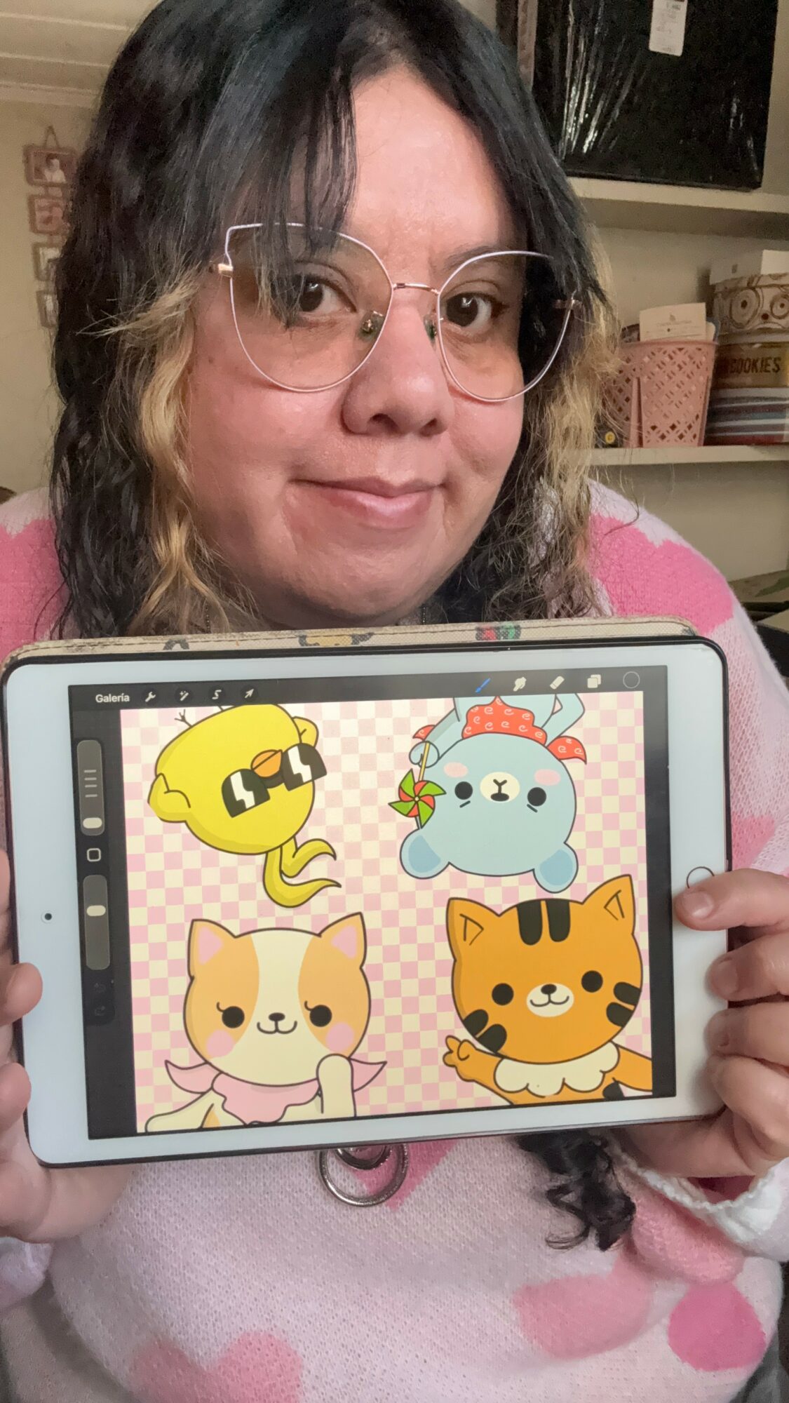 Person holding a tablet displaying four colorful cartoon animal characters, including a yellow bird, a blue bear, a pink cat, and an orange tiger.