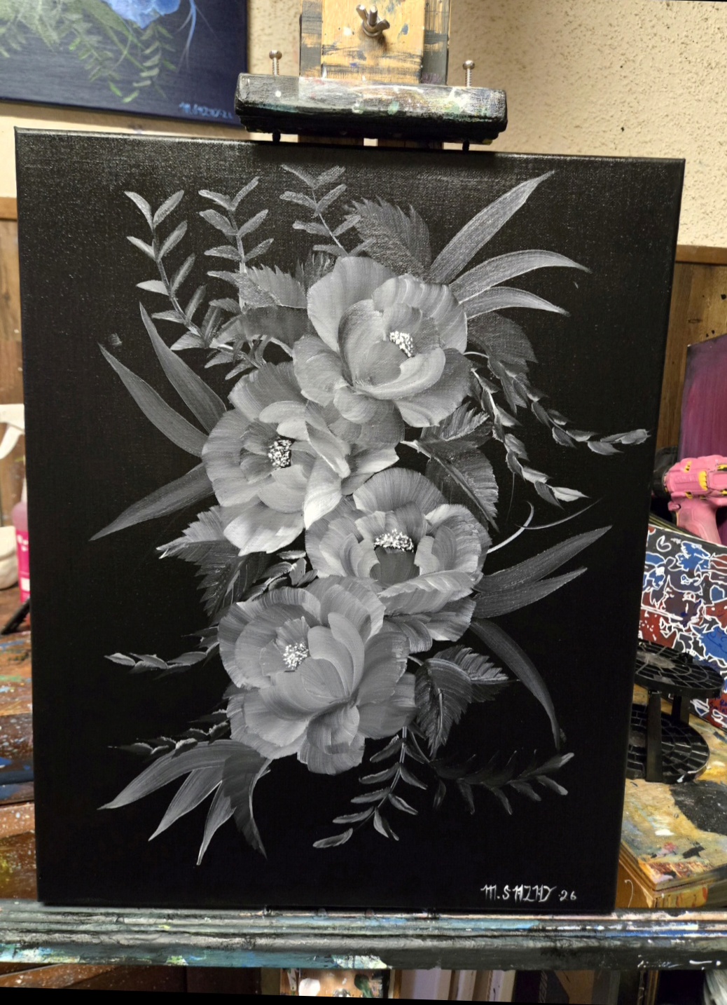 Black canvas with white floral design featuring large flowers and leaves, signed in the bottom right corner.