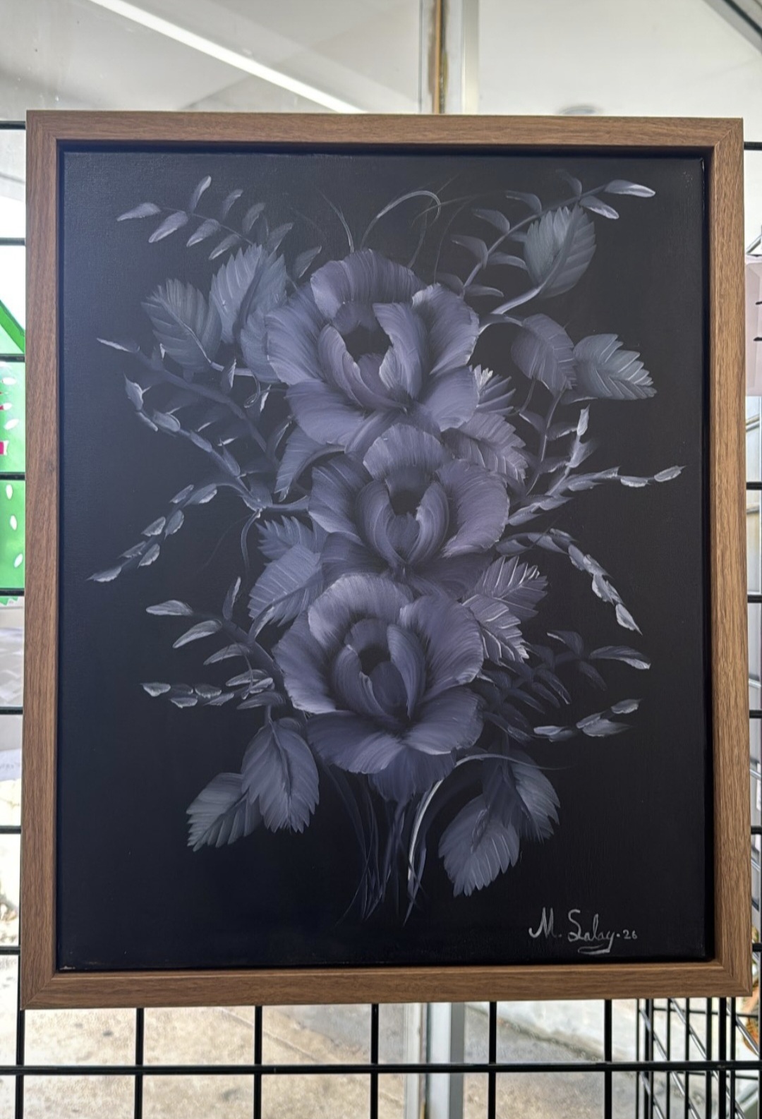 Framed blackboard with a monochrome floral drawing of roses and leaves, signed by artist in bottom right corner.