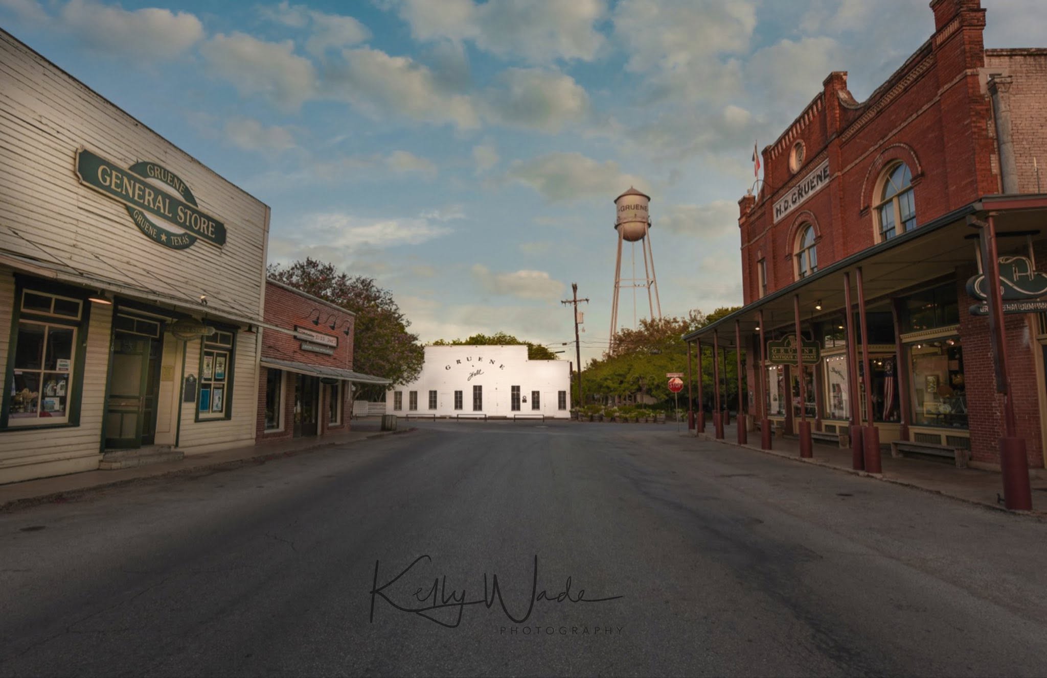 Empty street with historic buildings, water tower, and a white circular building in the background.