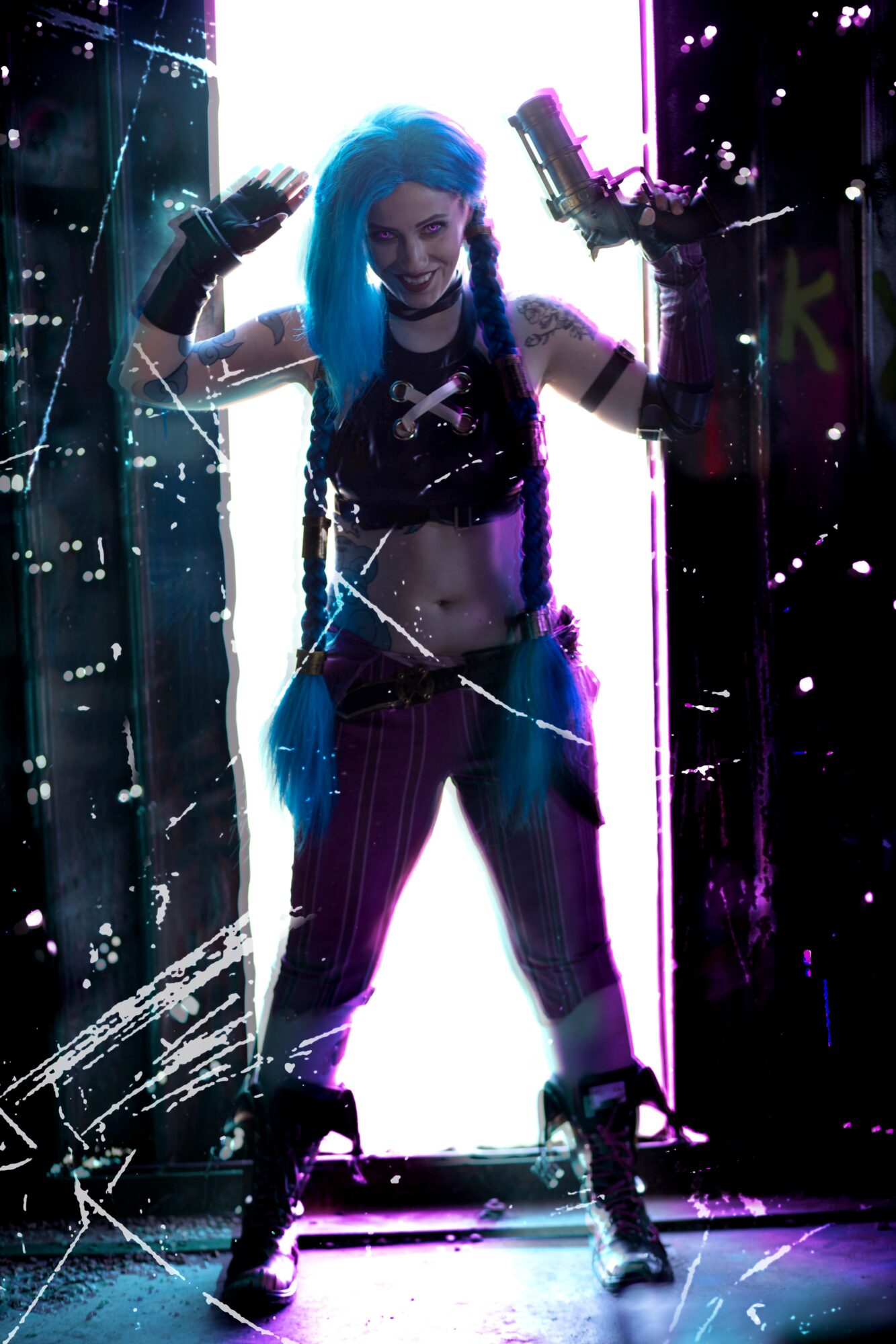 Person with blue hair and striped pants standing in a neon-lit environment, arms raised, with water spray around them.