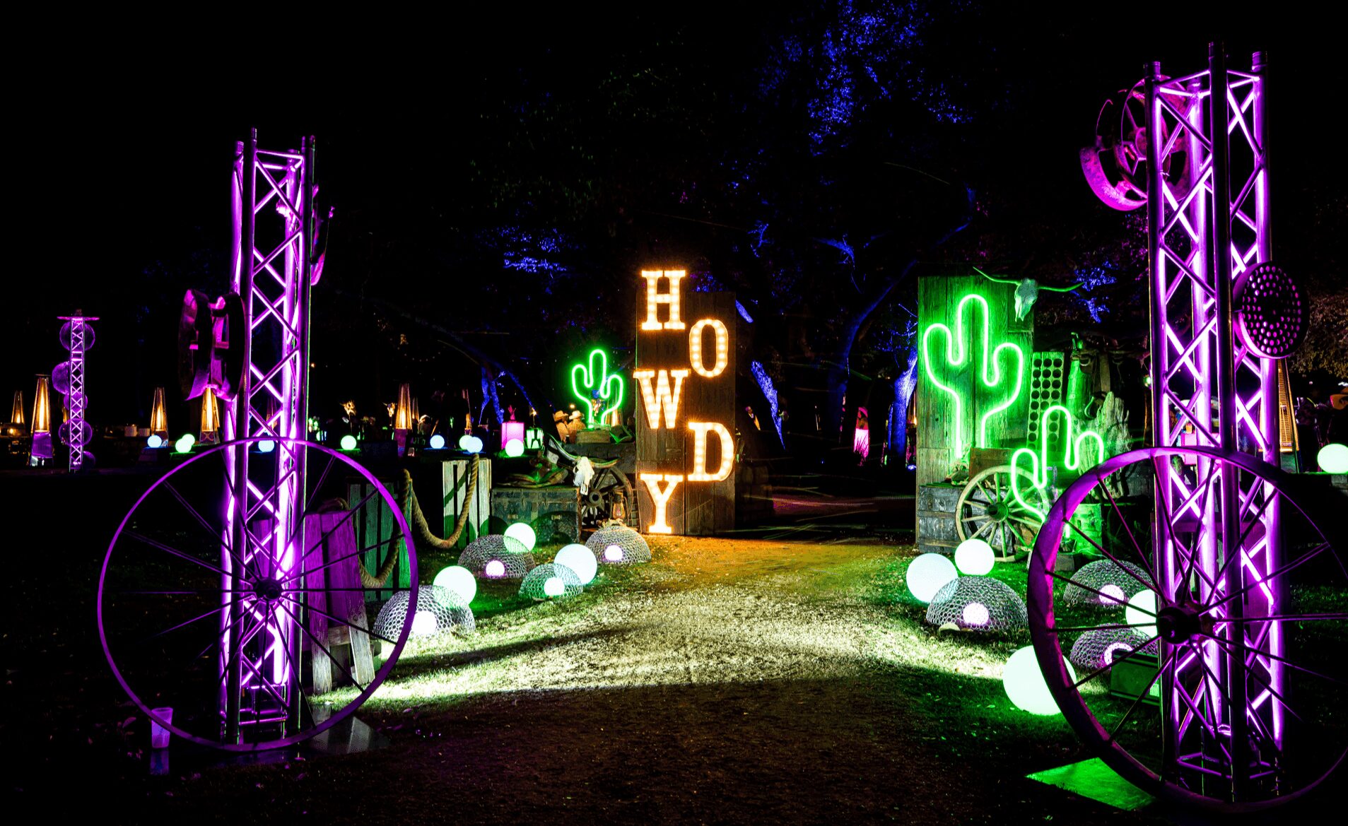 Neon-lit outdoor scene with purple structures, green cacti, glowing white spheres, and a sign reading 'HWD' at night.