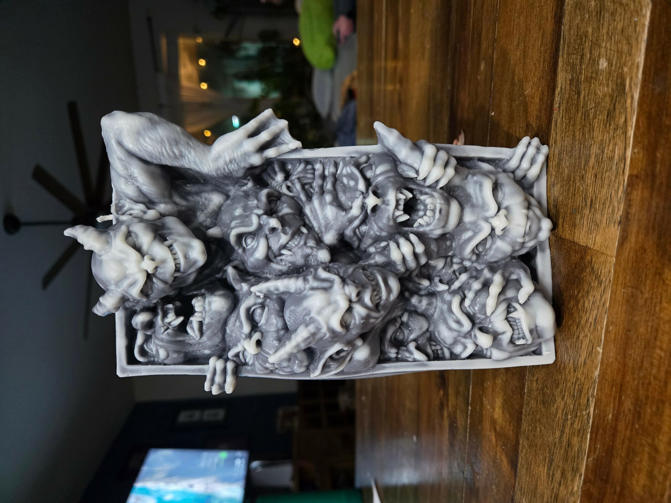 A detailed sculpture of multiple unicorns and mythical creatures in a rectangular container on a wooden surface.