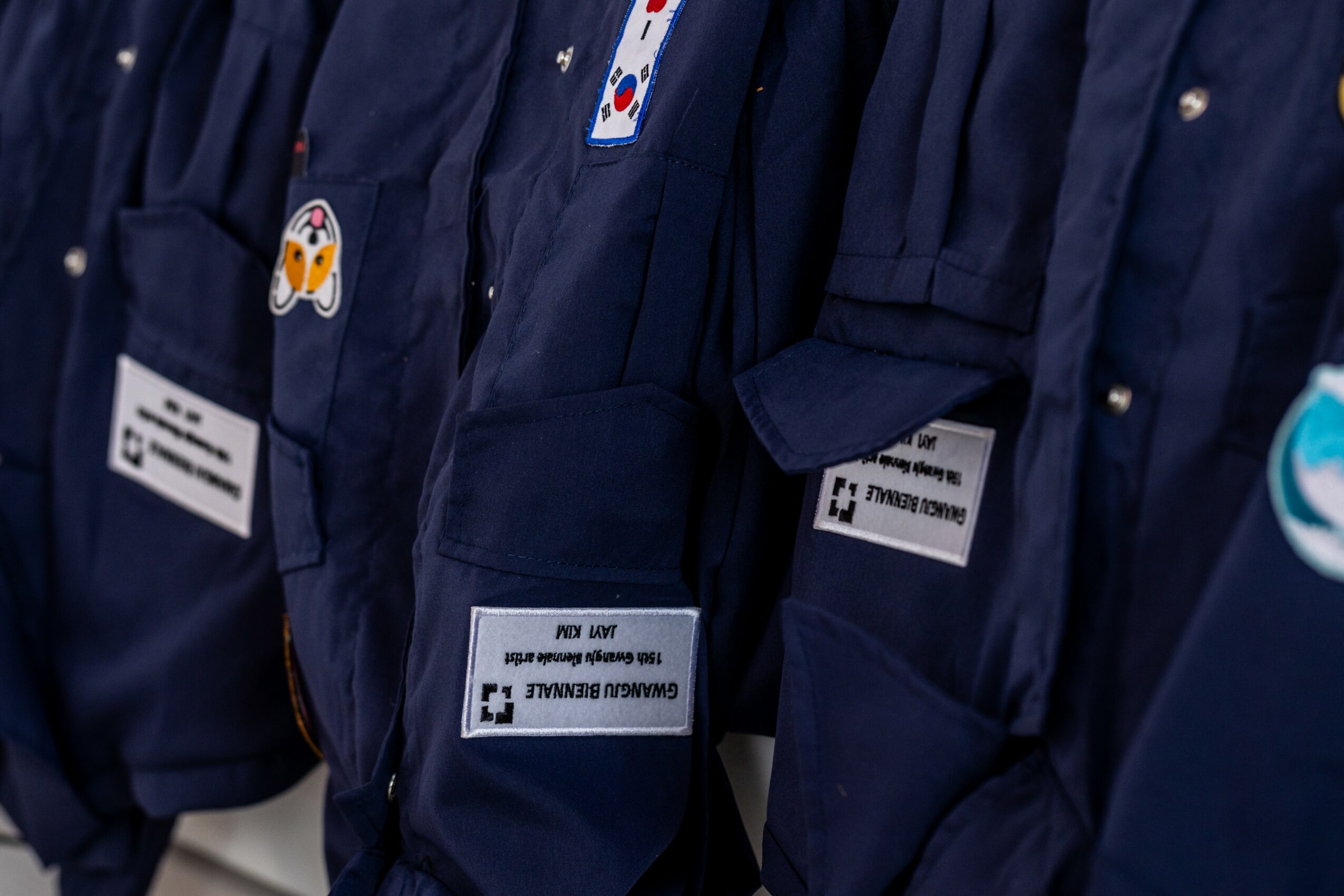 Close-up of people wearing navy uniforms with name tags and patches, standing in a row.
