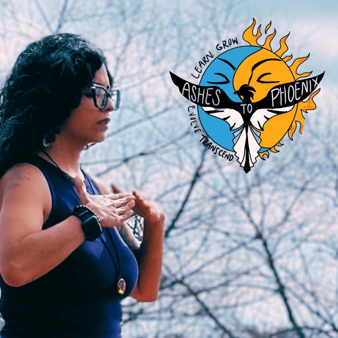 Woman with glasses and dark hair holding a small object outdoors, with a logo of a phoenix and sun in the sky.
