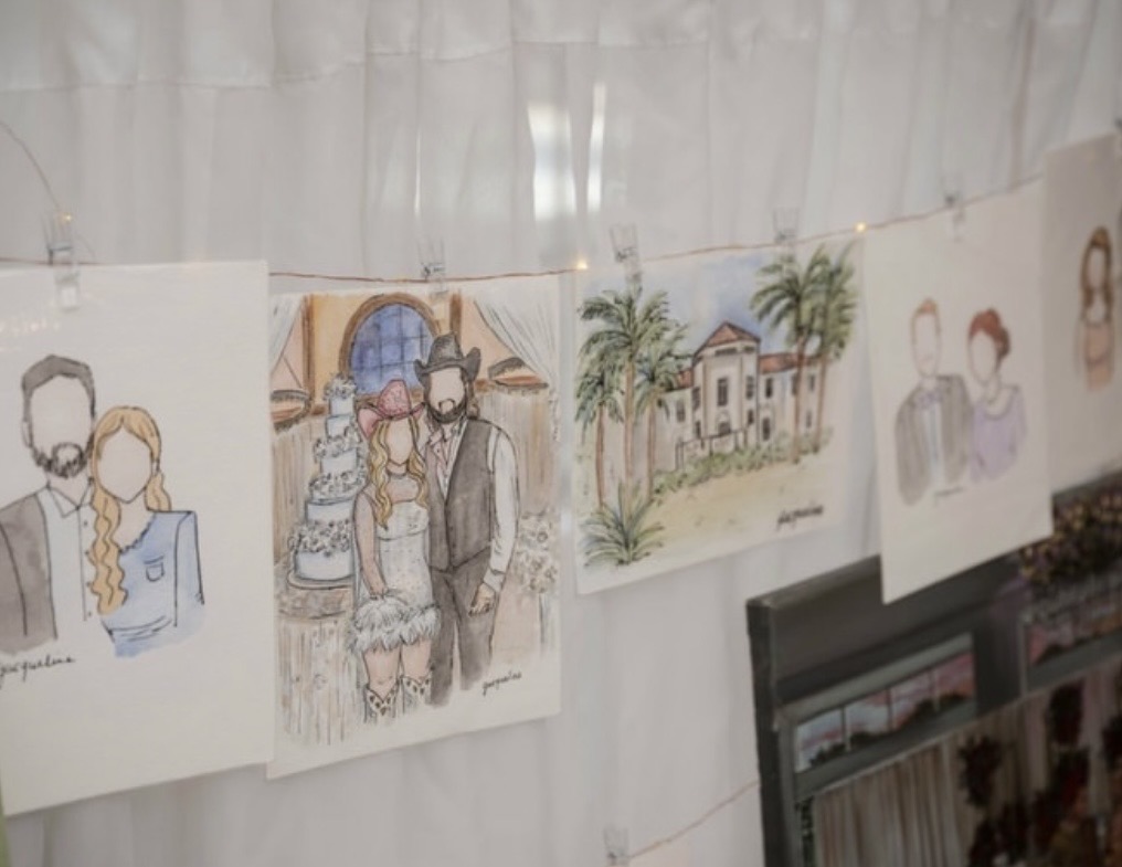 Set of hand-drawn illustrations hanging on a string, depicting people, buildings, and trees, with a white curtain background.
