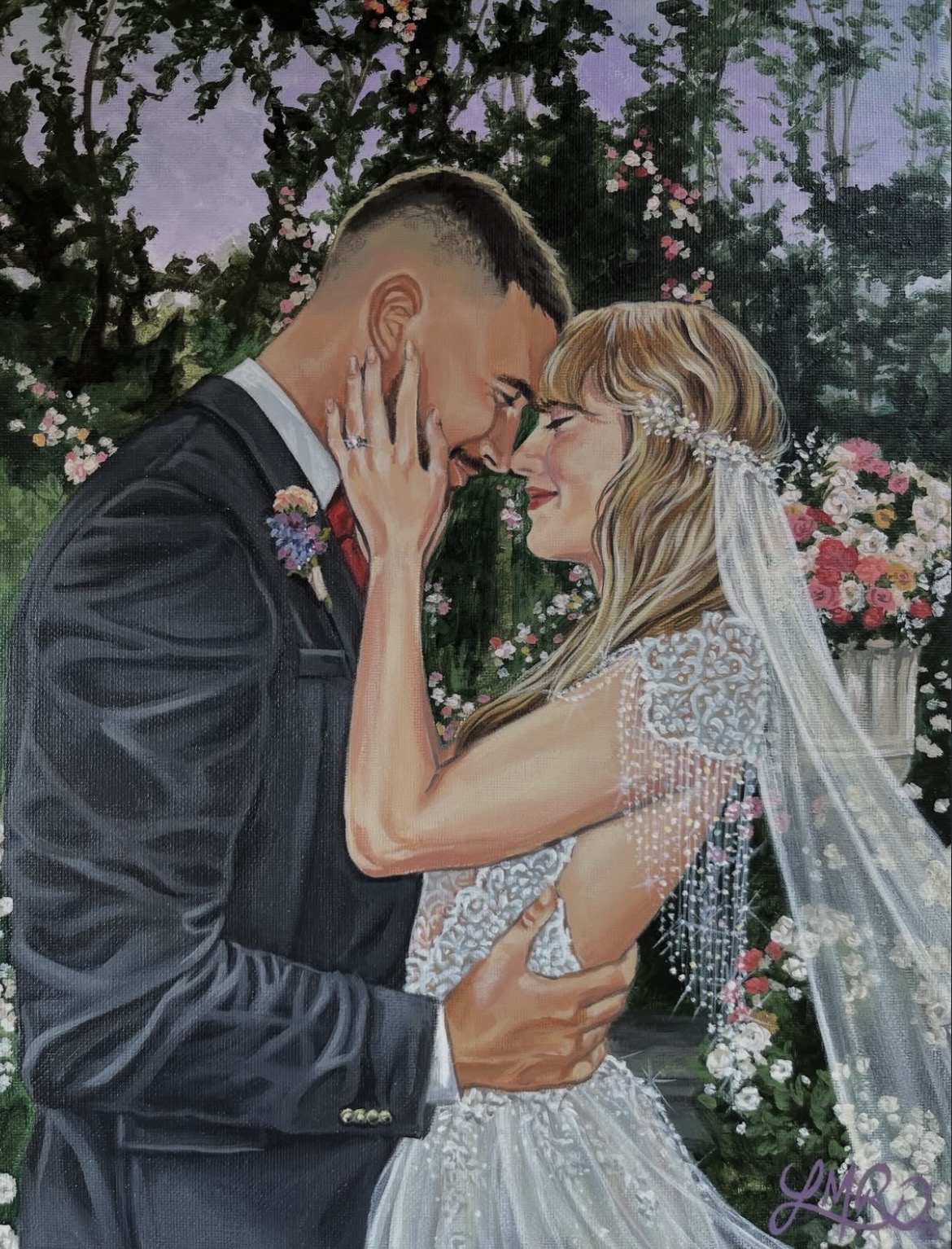 A couple in wedding attire face each other outdoors, touching foreheads with eyes closed, surrounded by flowers and trees.