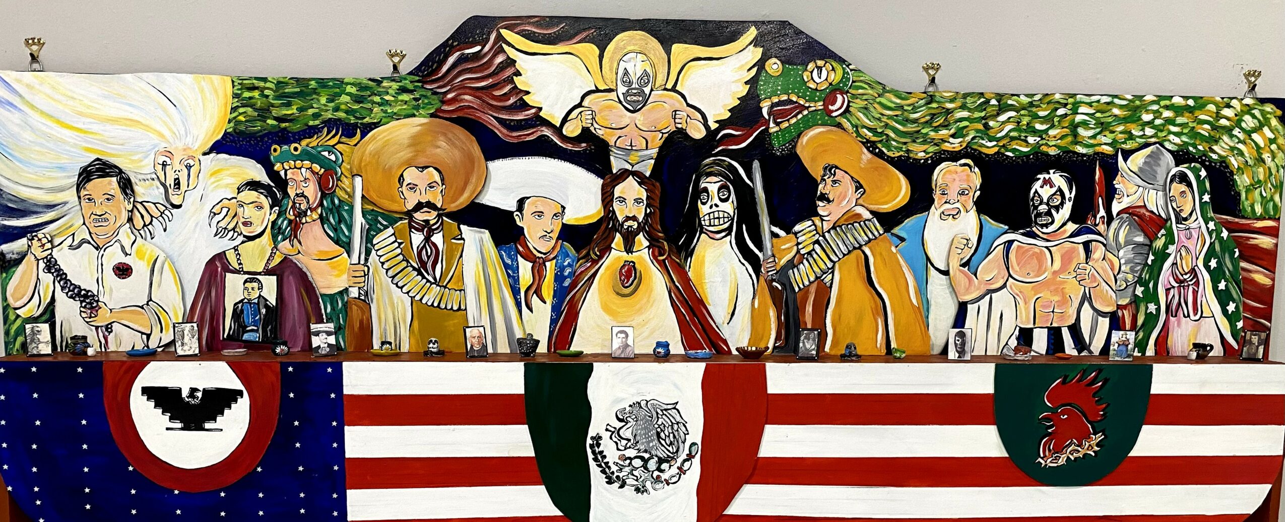 Colorful mural of diverse people above flags of the United States, Mexico, and Turkey, with a central emblem and decorative elements.