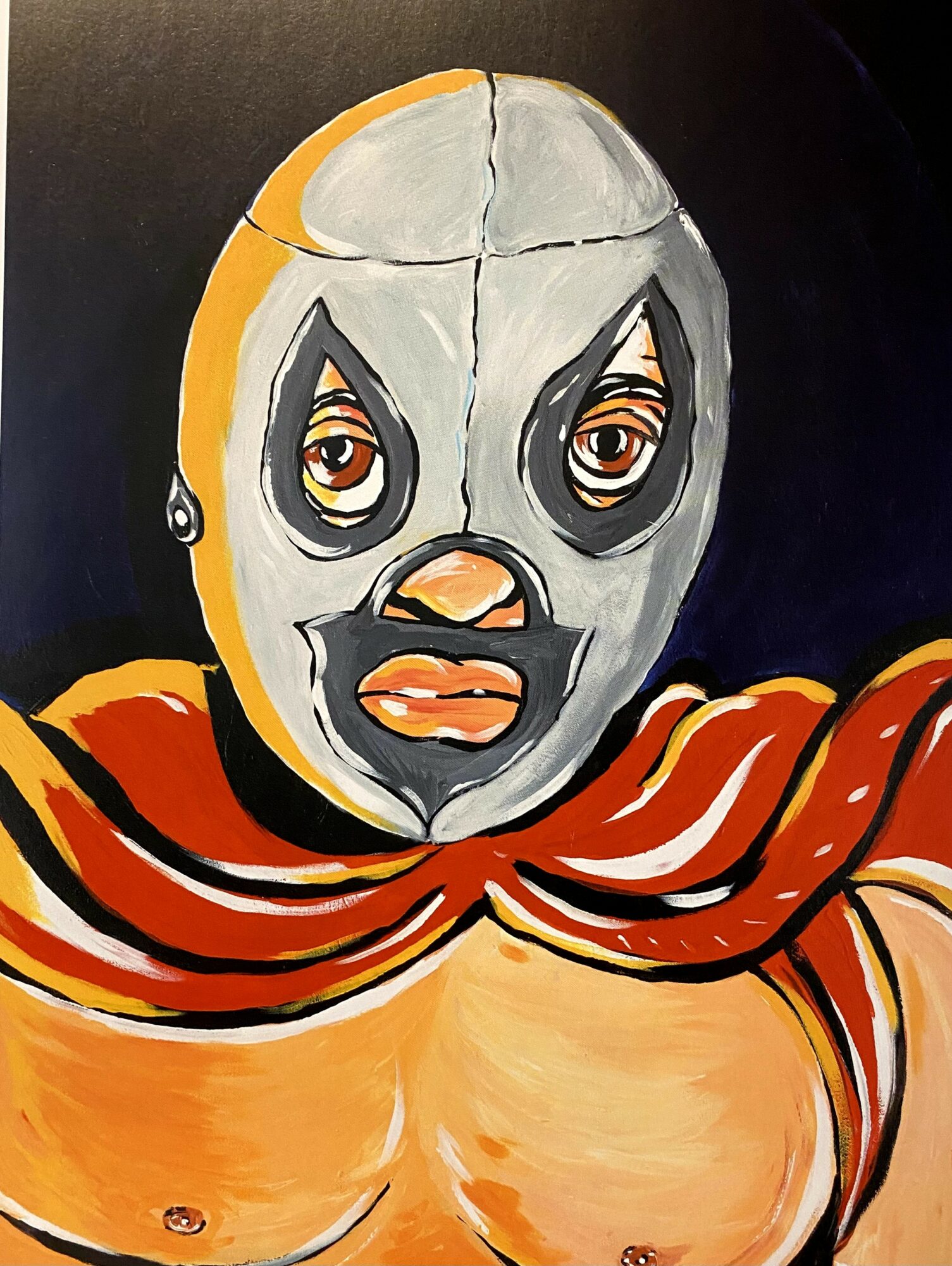A painted face with exaggerated features, wearing a mask-like face with large eyes, a nose, and lips, draped in an orange cloth.
