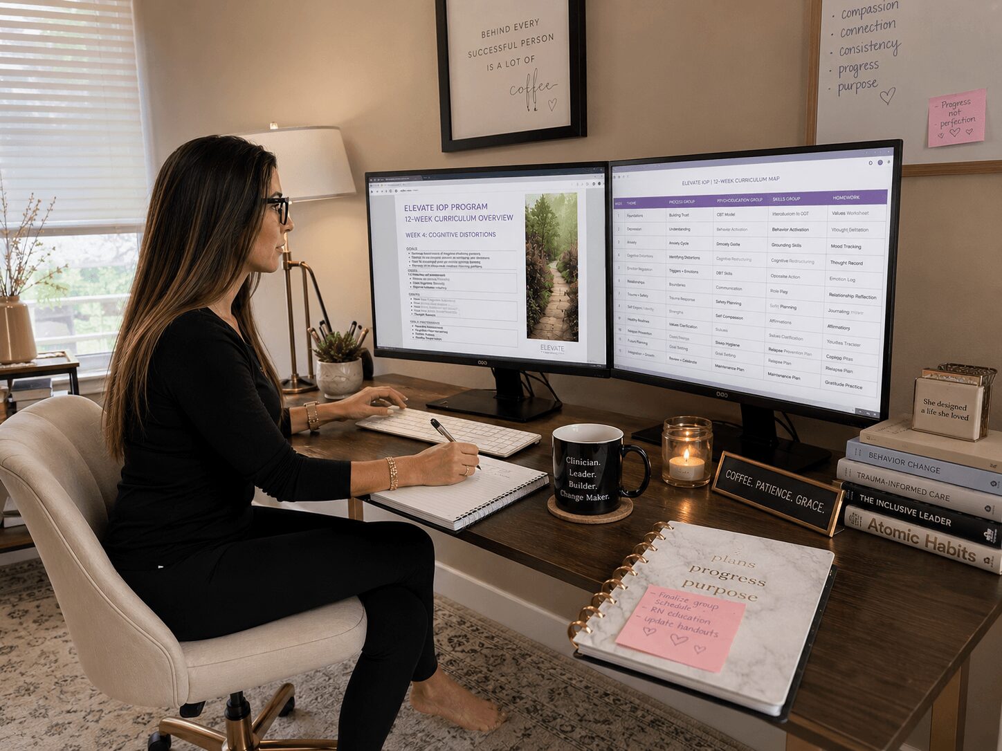 Woman working at desk with two monitors, notebooks, mug, and candles in a home office.