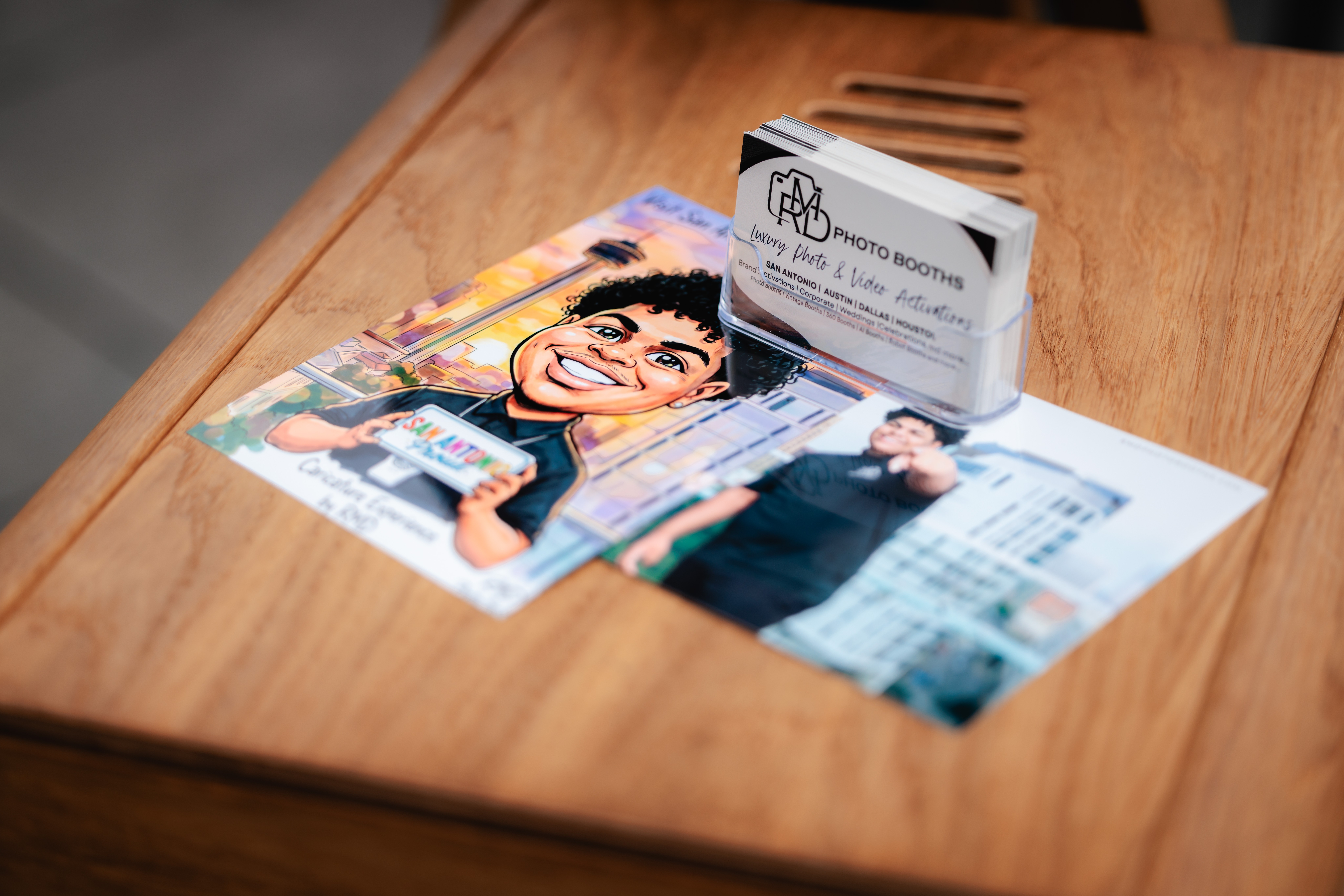 Business cards and colorful illustrations on a wooden surface, with a blurred background.