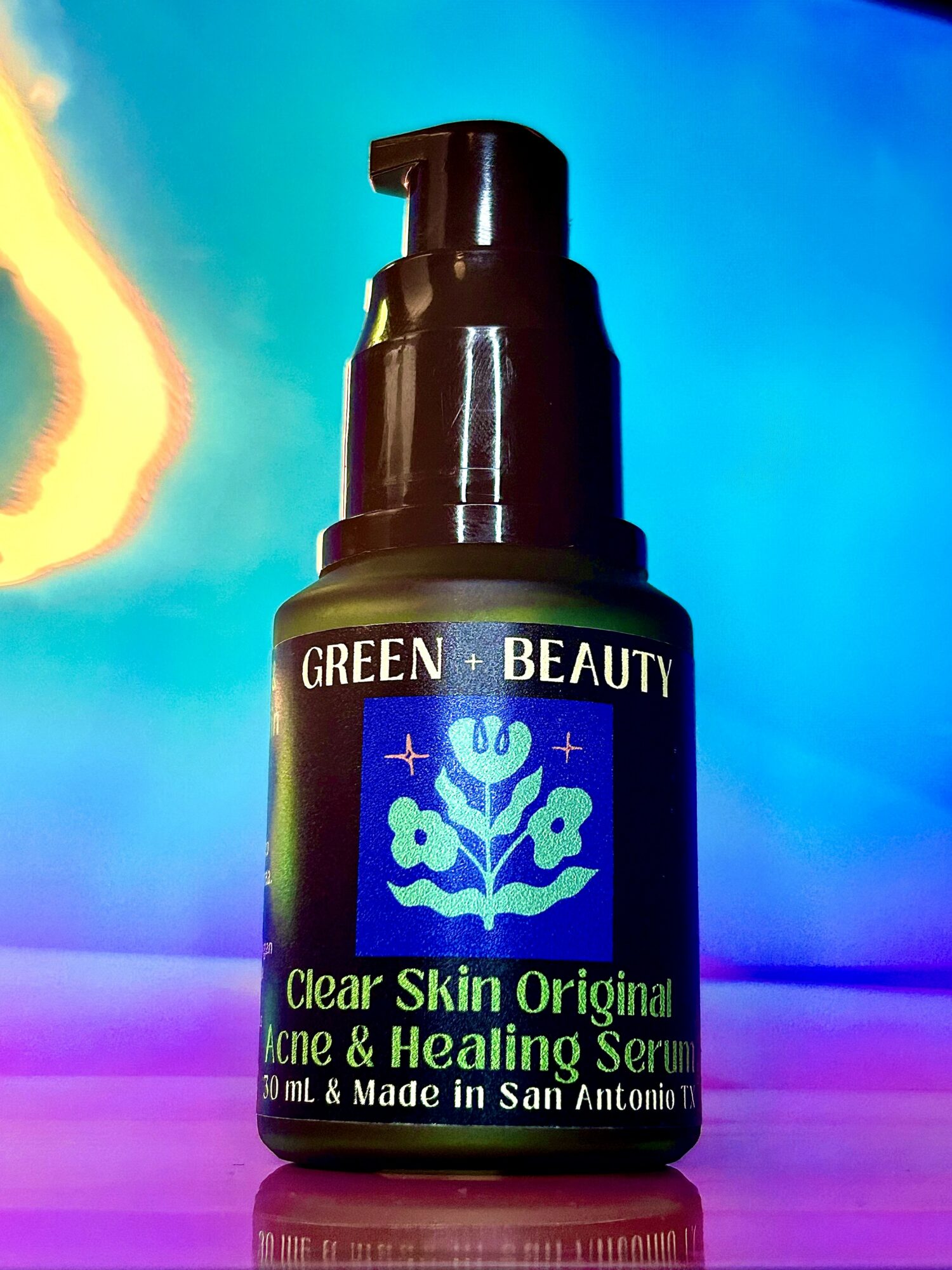 Bottle of Green Beauty Clear Skin Original Acne & Healing Serum with pump dispenser, label visible, colorful background.