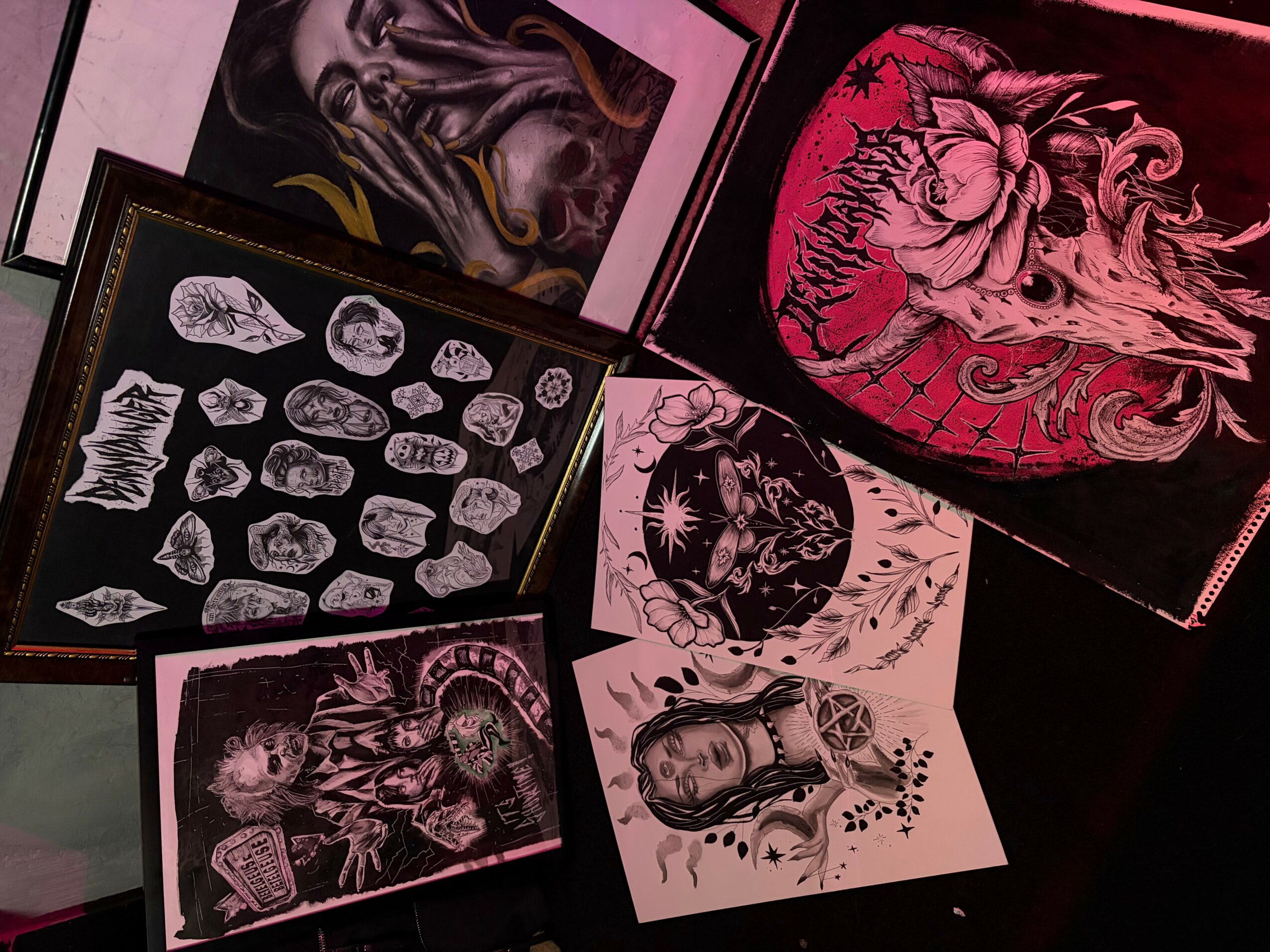 Collection of tattoo flash designs featuring skulls, animals, and mythical creatures, in black, white, and pink colors.
