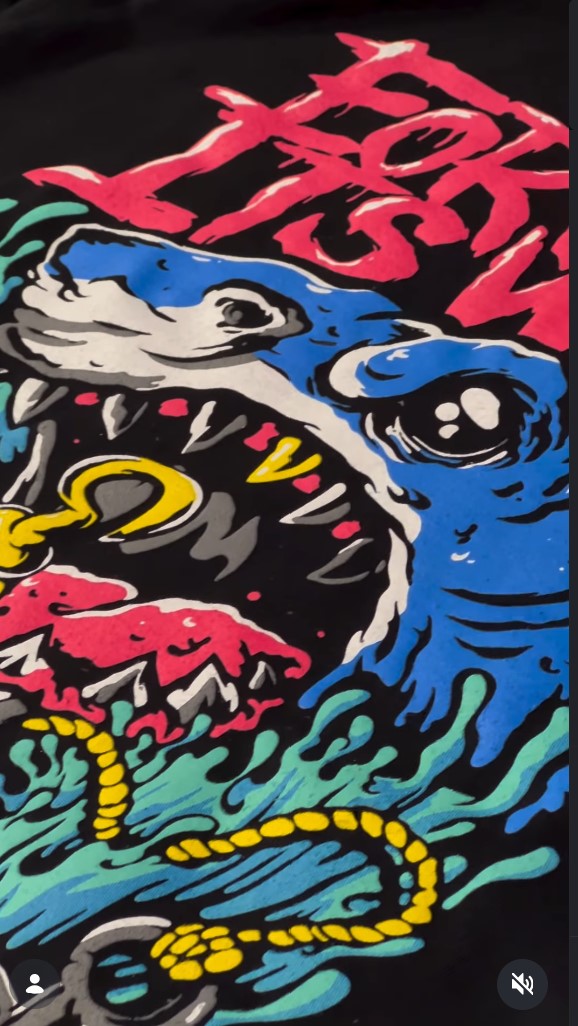 A colorful illustration of a crocodile with an open mouth, sharp teeth, and a yellow chain, with stylized text above.