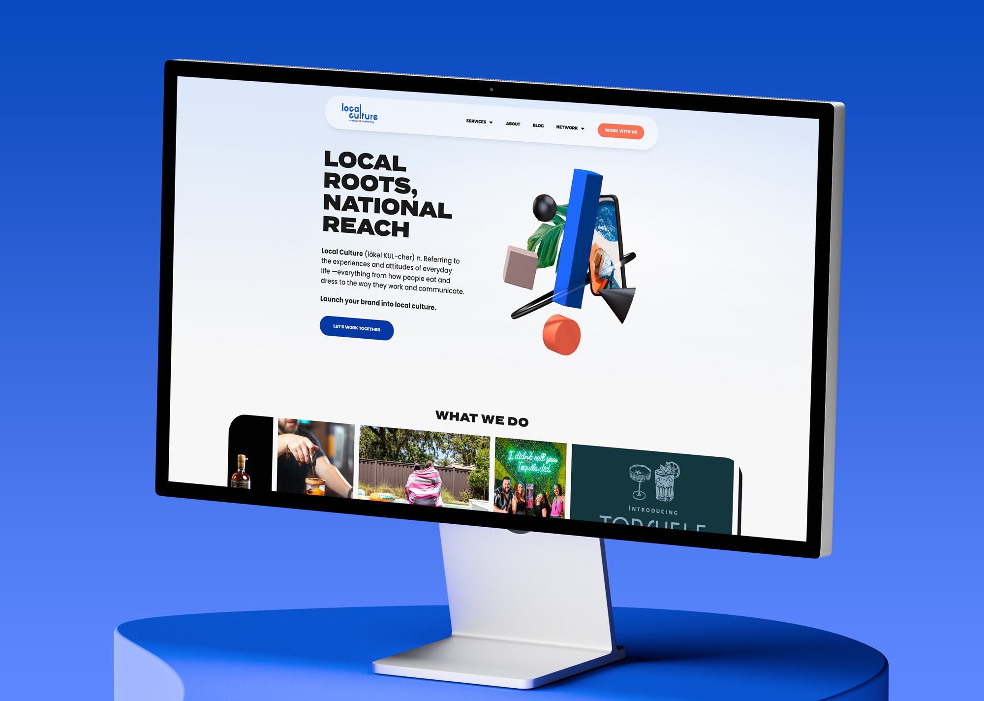 Computer monitor displaying a website with text and graphics, placed on a blue surface against a blue background.