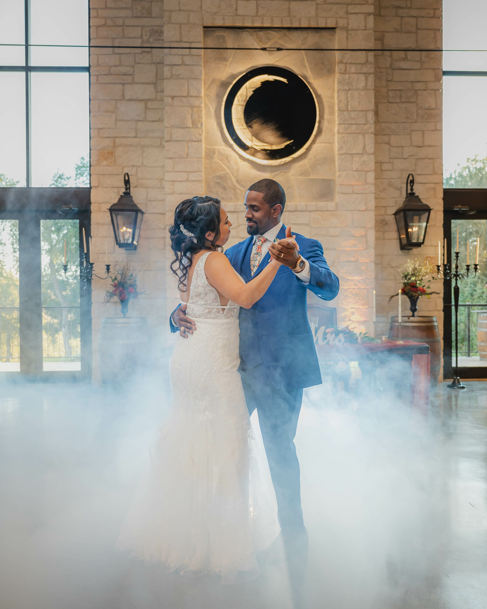 Couple dancing indoors with a moon symbol on the wall, surrounded by fog, two lanterns, and large windows.