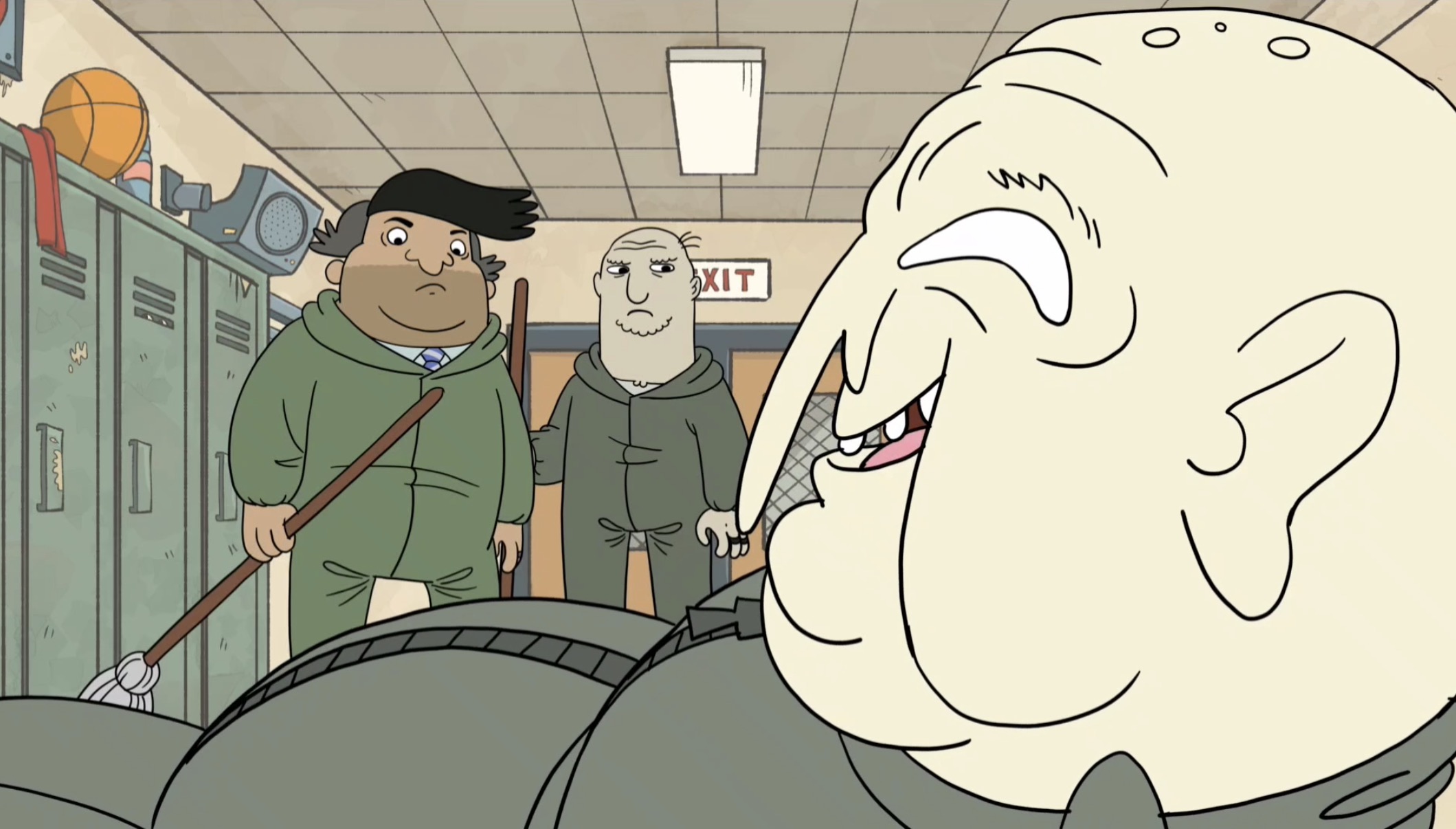 Two students in a school hallway look at a large, smiling, elderly person with exaggerated features. Lockers are visible in the background.