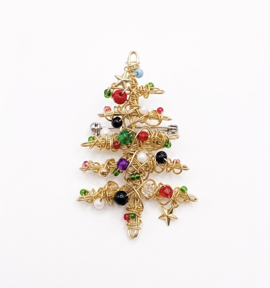 Gold Christmas tree ornament with colorful beads and star shapes on a white background.