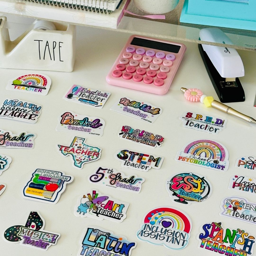 Desk with calculator, tape dispenser, colorful stickers, and office supplies on a white surface.