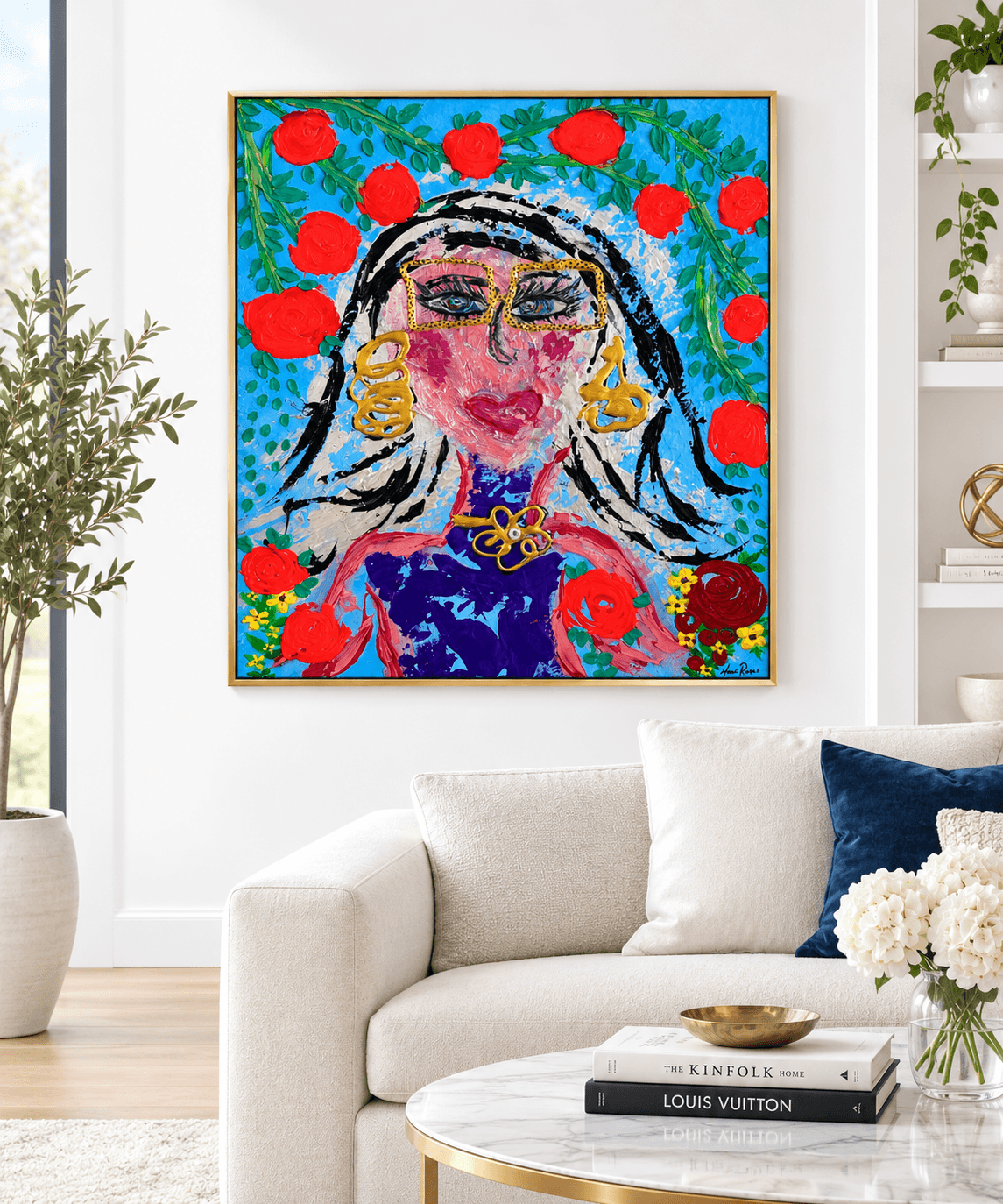 Colorful abstract portrait of a woman with earrings, surrounded by red circles and blue background, in a frame on a white wall.