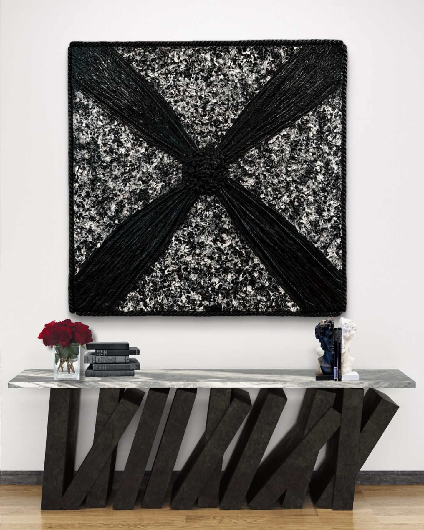 Black and white textured artwork with black diagonal lines, placed above a modern black and gray console table with decorative items.