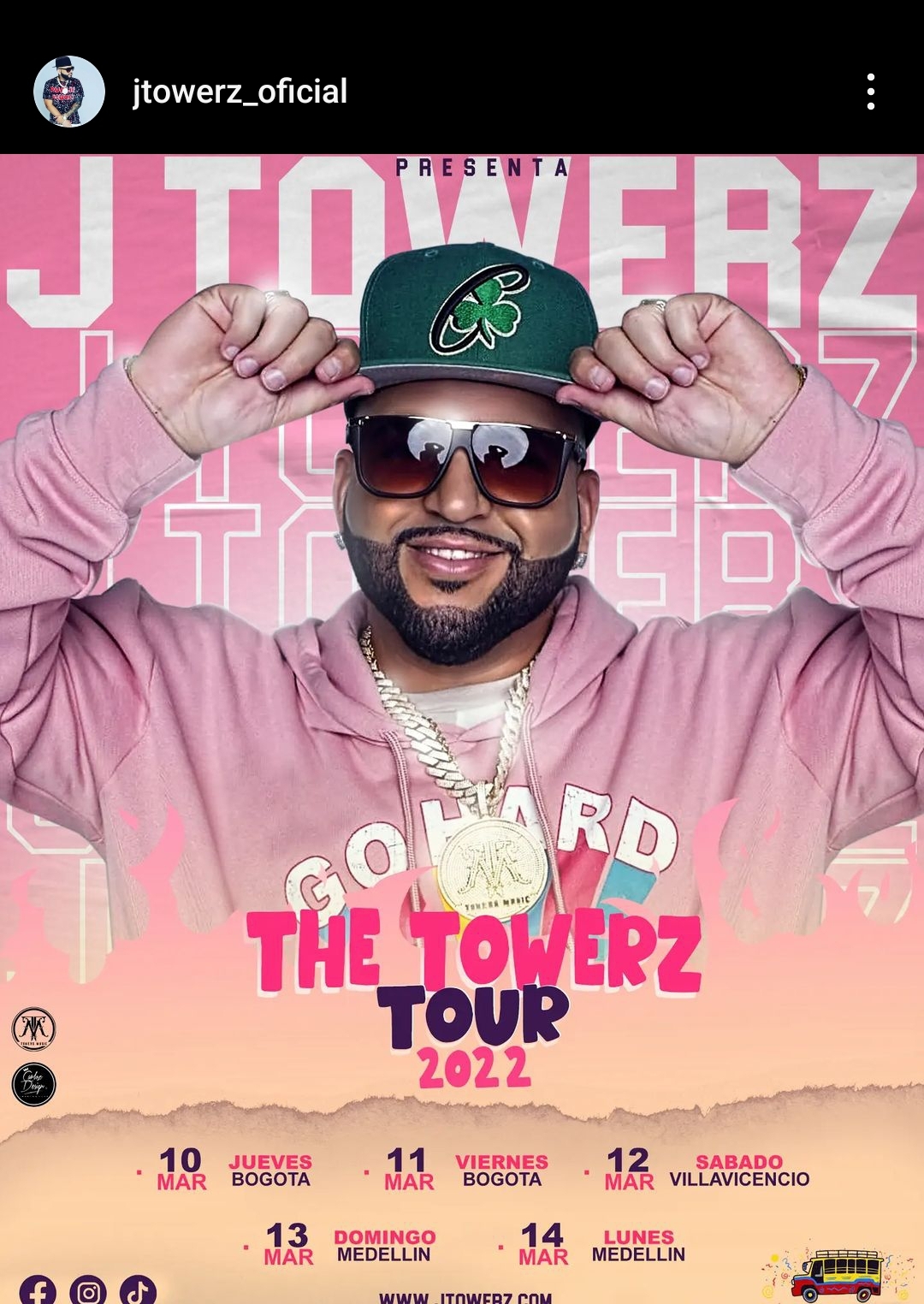 Man wearing sunglasses, pink hoodie, and a cap with a logo, smiling and holding the cap's brim, pink background with text.
