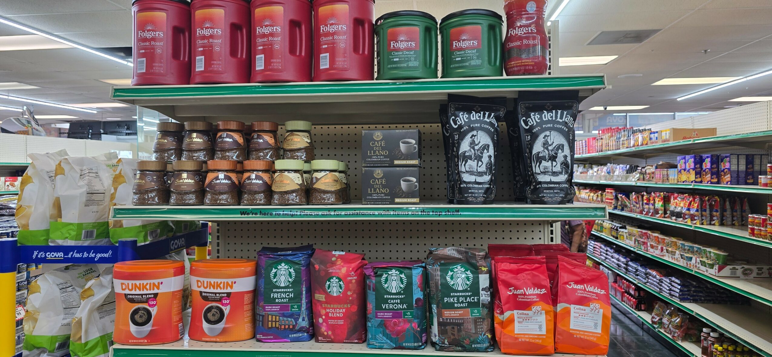 Shelves with coffee products, including bags and jars, in a grocery store aisle.